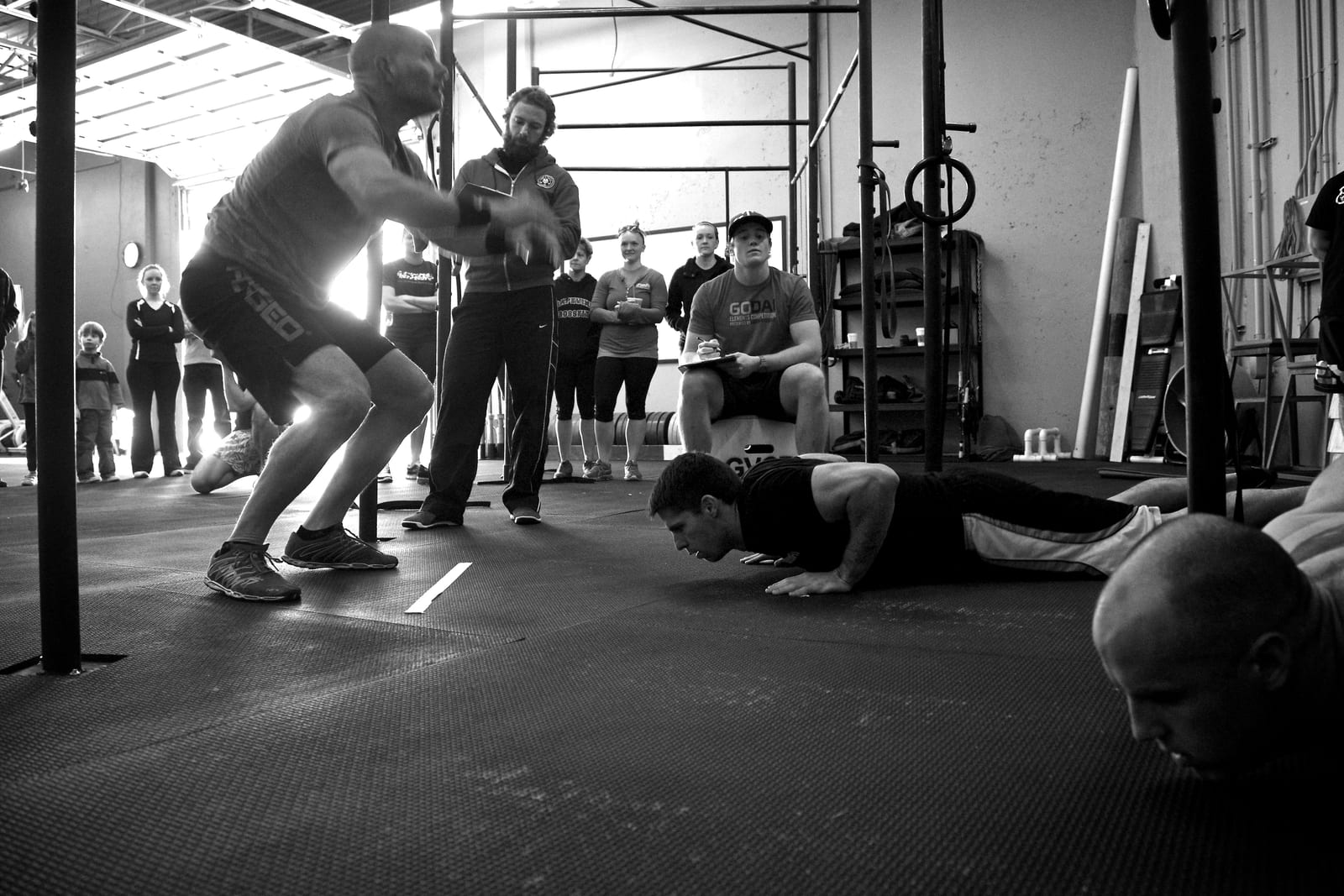 Athletes doing burpees in competition while judges watch