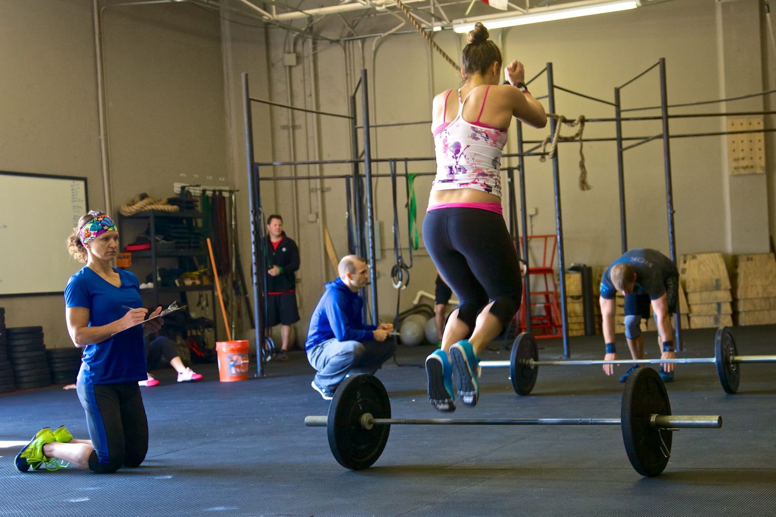 A functional fitness gym with barbells on the floor and judges